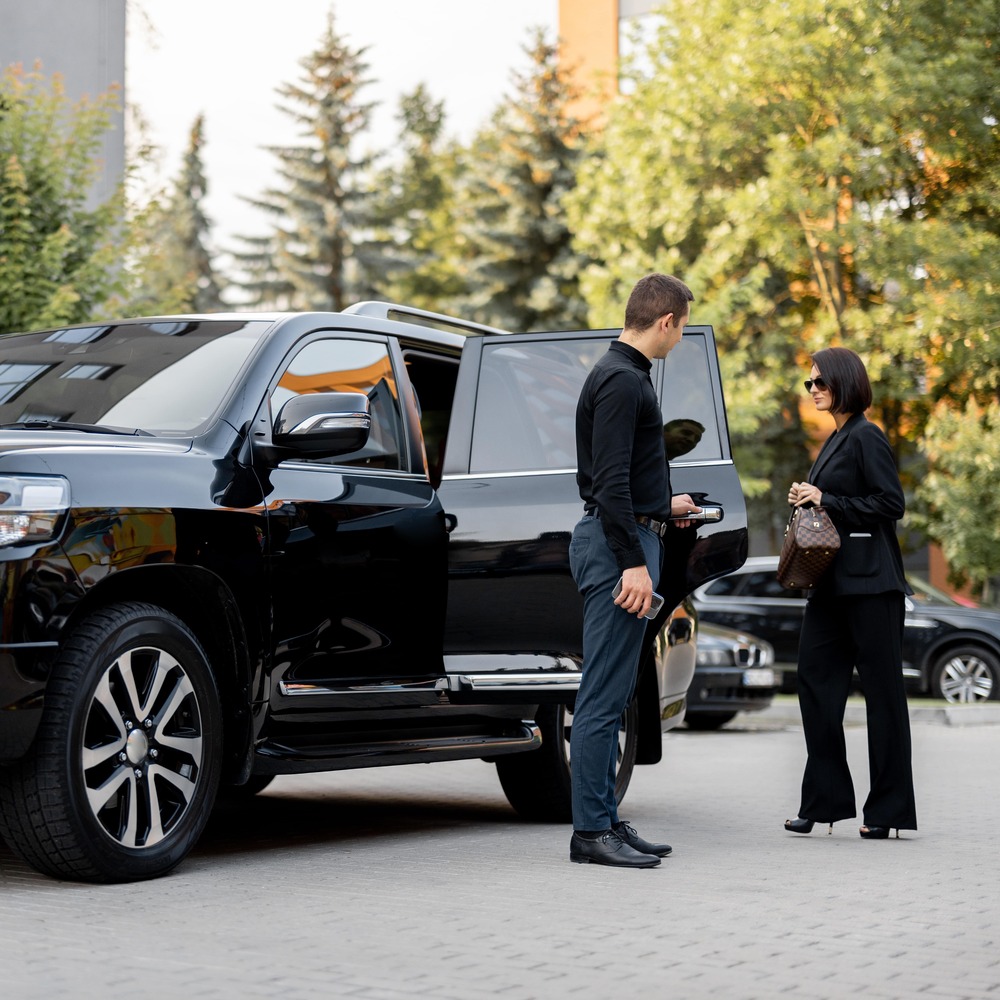 Lady Being Picked Up by a Chauffeur in a Black Ford Explorer